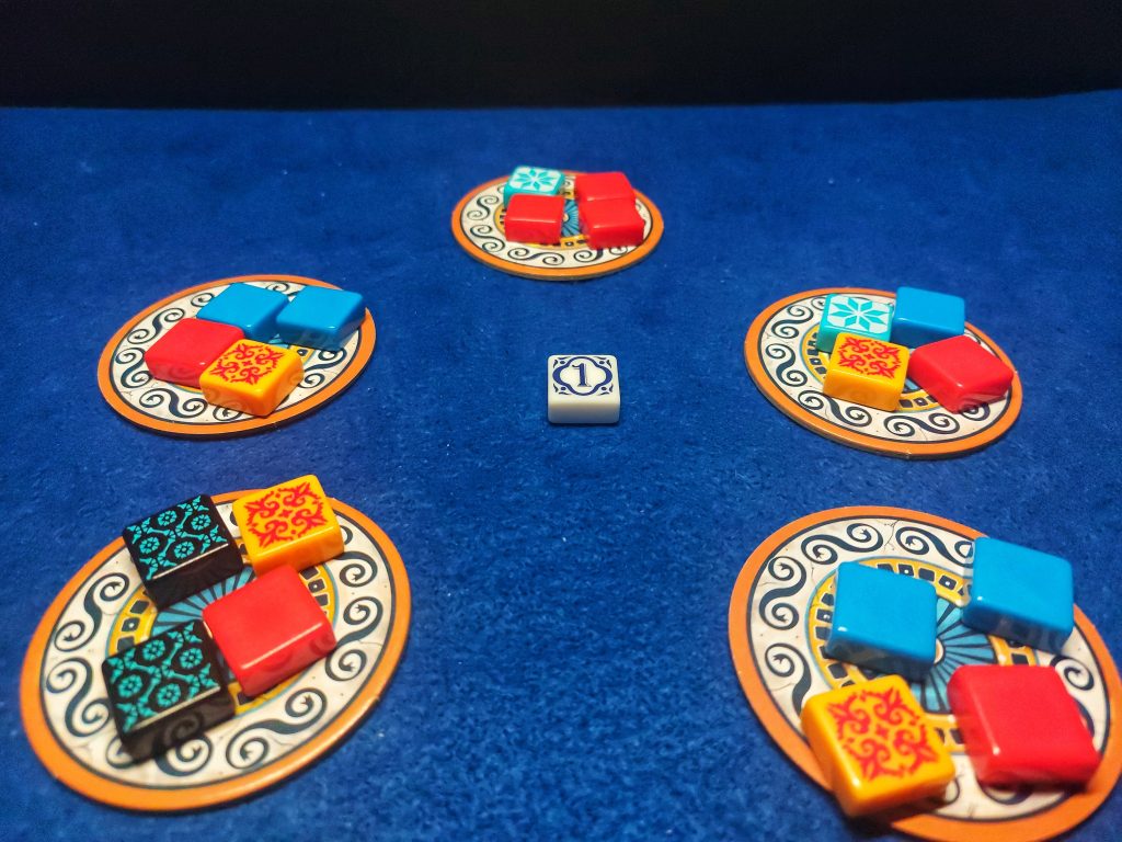 Juego de mesa azul. Setup para 2 jugadores. Centro de la mesa con piezas colocadas