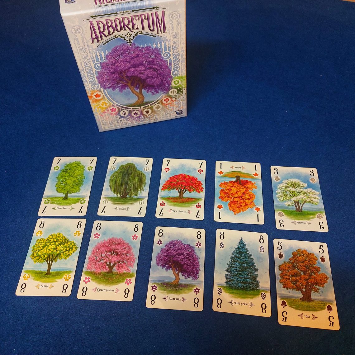 Juego de mesa Arboretum. Se muestra la caja y los 10 tipos de árboles que contiene el juego.