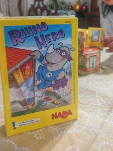 Juego de mesa Rhino Hero colocado sobre una mesa. Al fondo se observa el inicio de una partida